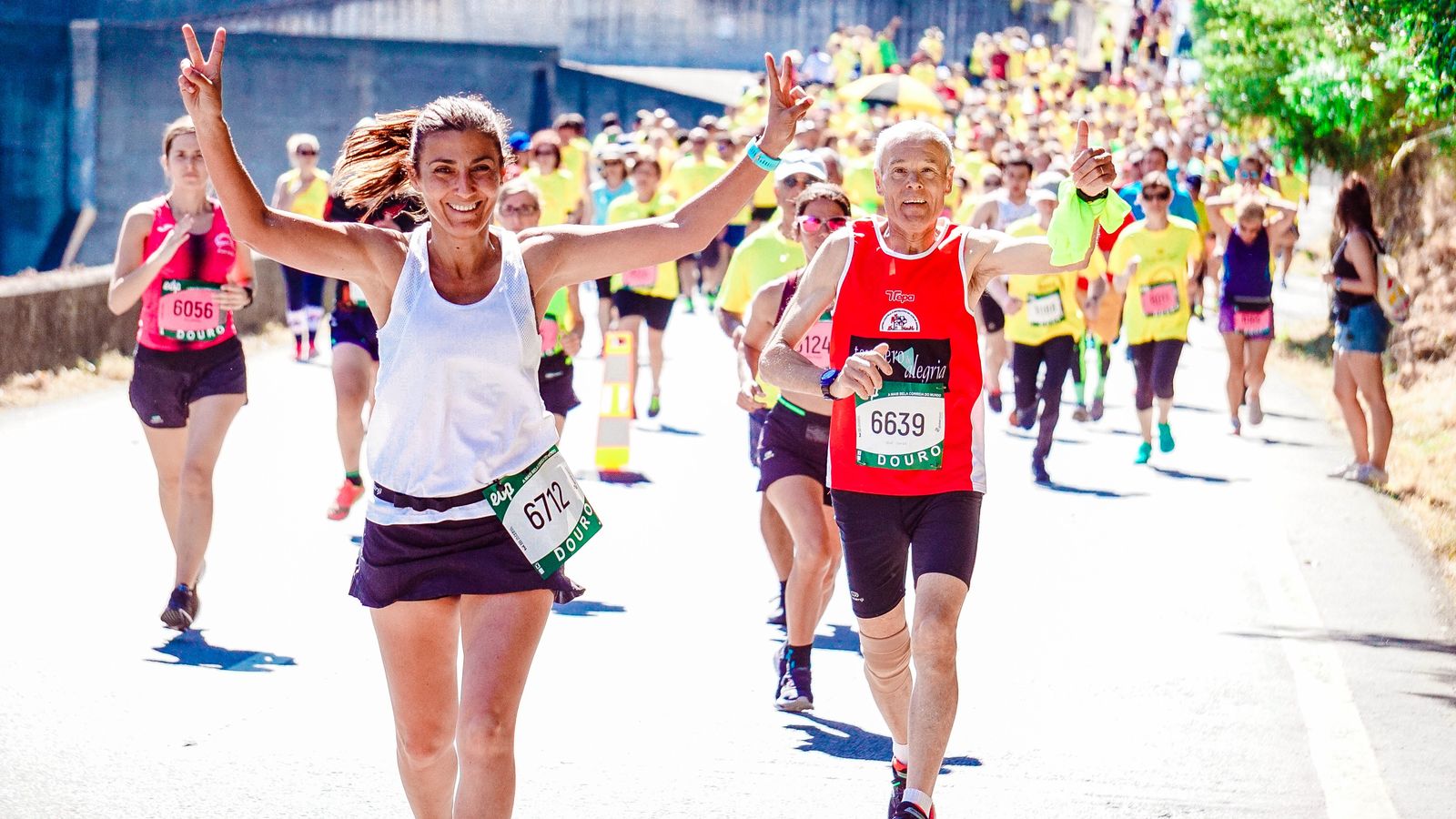 A large group of runners moving together down a road.